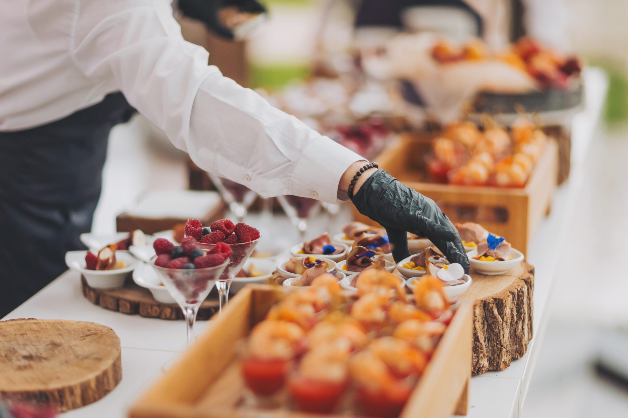Hands,Of,A,Waiter,Prepare,Food,For,A,Buffet,Table