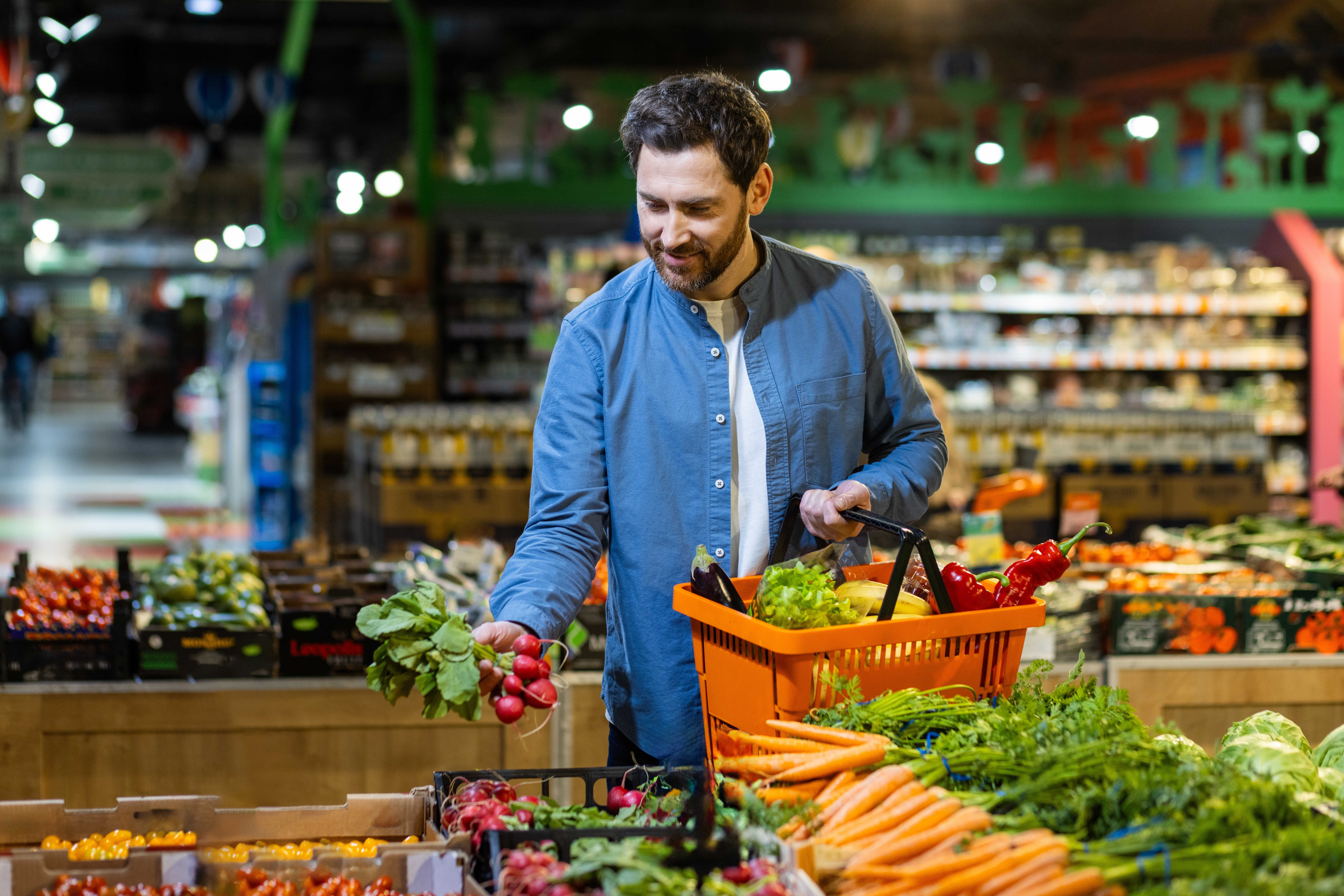 Man,Selecting,Fresh,Vegetables,In,Grocery,Store,,Holding,Orange,Basket,