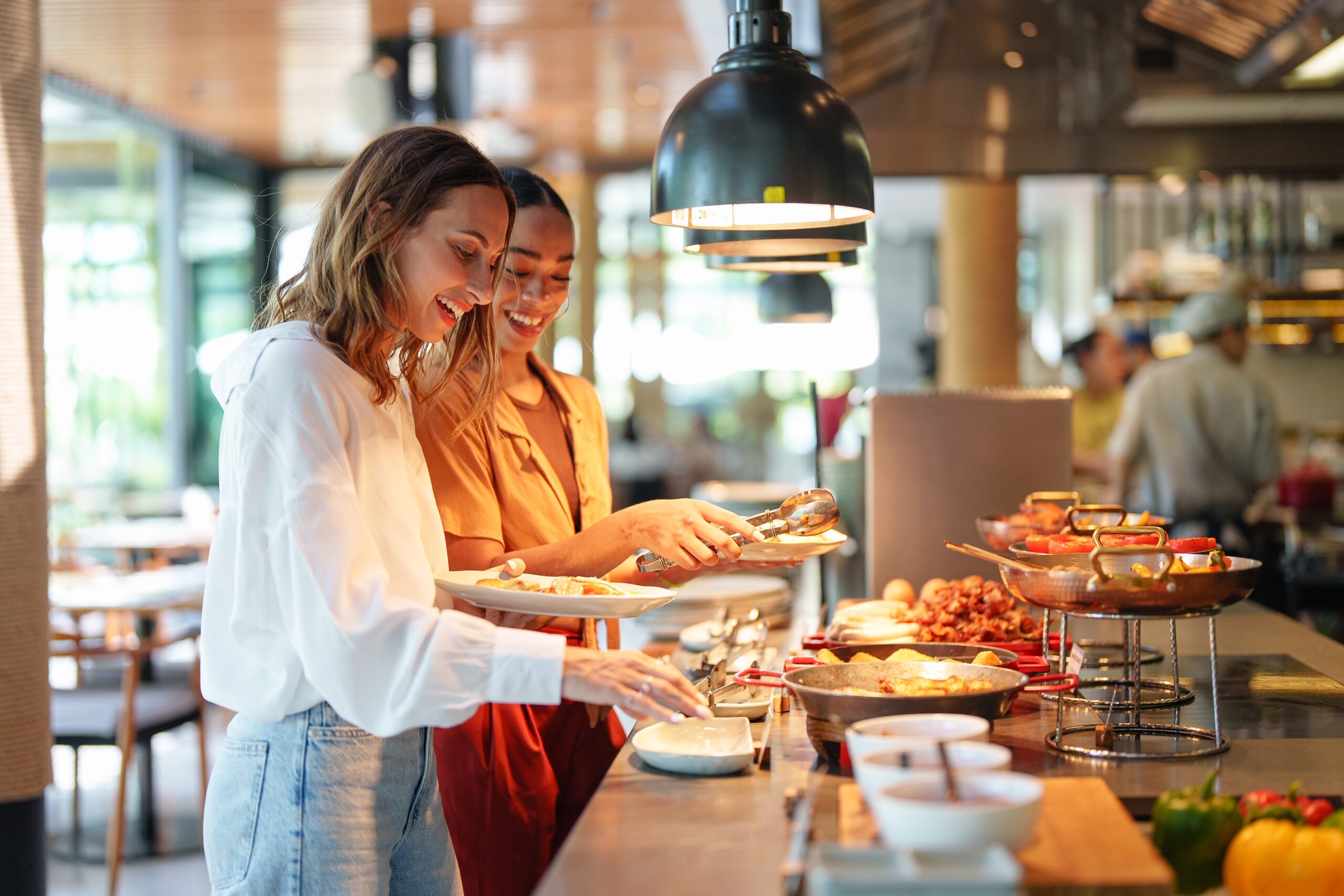 Young,Adult,Multiracial,And,Caucasian,Females,Smile,While,Selecting,Food